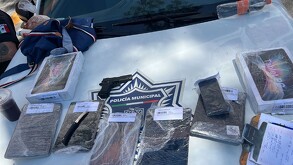 Elementos de policía aseguraron armas y dispositivos electrónicos tras el arresto.