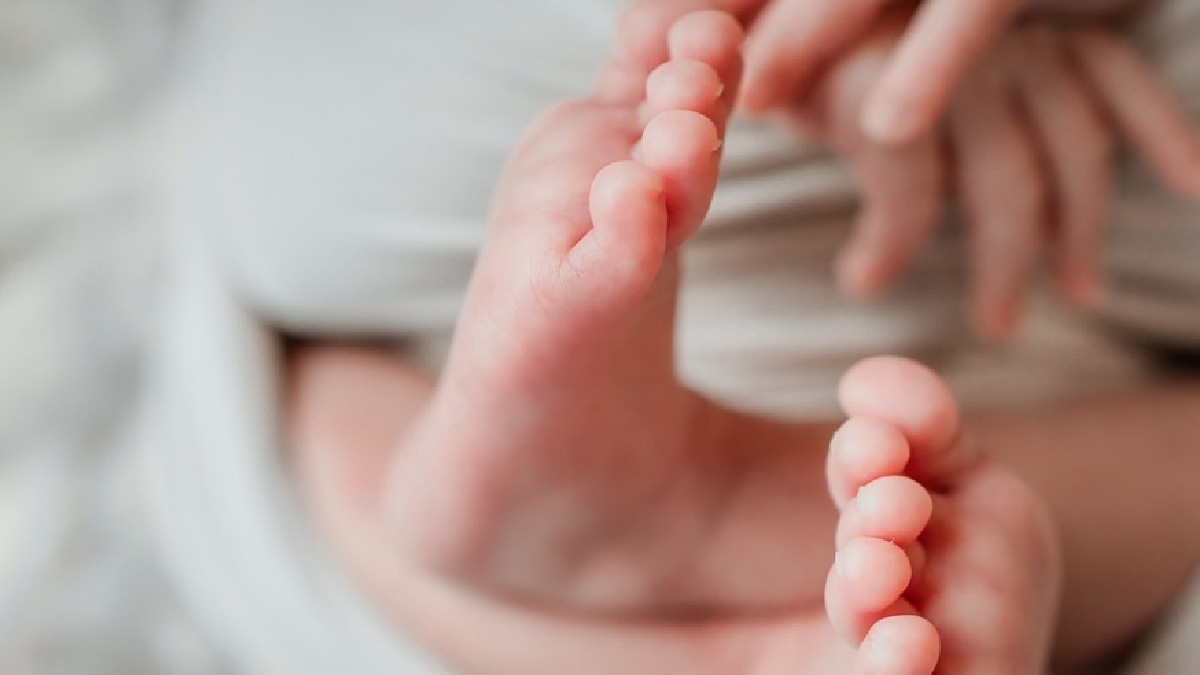 Pies de bebé con una sábana en color blanco