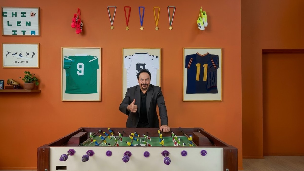 Hugo Sánchez parado de frente a un futbolito en el Airbnb del Estadio Azteca