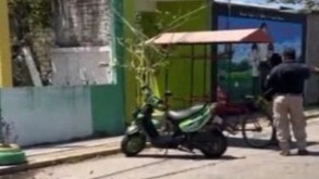 Motoneta junto a un par de hombres en una calle de Juchitán, en Oaxaca.