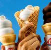 Varias personas sostienen conos de helado suave de Dairy Queen, mostrando el clásico diseño en espiral característico de la marca.