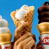 Varias personas sostienen conos de helado suave de Dairy Queen, mostrando el clásico diseño en espiral característico de la marca.