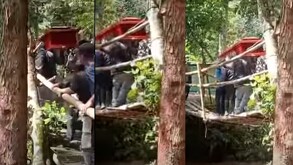 Puente de madera junto a varias personas cargando un ataúd en color café