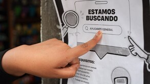 Un dedo señalando una oferta de empleo pegada en la calle.