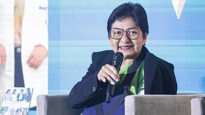 Adulta mayor habla frente a un micrófono.