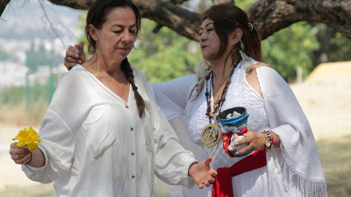 Mujer con sahumerio purifica a otra mujer, ambas vestidas de blanco por el equinoccio de primavera en Cholula