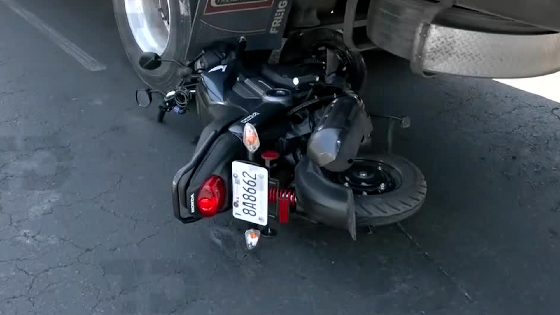 La mujer de nombre Isabel quiso pasar entre dos vehículos de carga y perdió el control de su motocicleta.