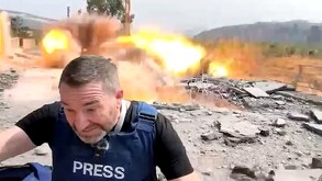Periodista Steve Sweeney cubriéndose tras la explosión de un misil de guerra a unos metros detrás de él