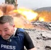 Periodista Steve Sweeney cubriéndose tras la explosión de un misil de guerra a unos metros detrás de él