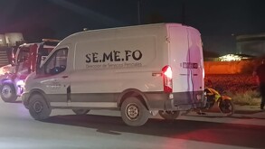 Camioneta de SEMEFO en color blanco junto a moto de policía