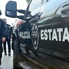 Vista del costado de una patrulla de la Policía del Estado de Jalisco con un oficial con un arma larga caminando a un lado