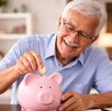 Imagen de adulto mayor ahorrando monedas en alcancía como parte de su planificación financiera en la jubilación