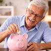 Imagen de adulto mayor ahorrando monedas en alcancía como parte de su planificación financiera en la jubilación