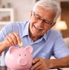 Imagen de adulto mayor ahorrando monedas en alcancía como parte de su planificación financiera en la jubilación