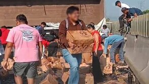 personas se llevan cartones de cerveza de un camión que se accidentó en veracruz