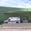 Se observa una fachada color verde con blanco, dice un letrero Urgencias.