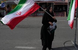 Una mujer ondea una bandera iraní durante una campaña a favor del gobierno en la plaza de la Revolución Islámica en el centro de Teherán,