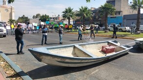 Lanchas bloqueando la Avenida Federalismo en Guadalajara con cientos de manifestantes con redes de pescar y carteles de protesta