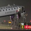 Avión de Air Canada inclinado con la parte de la cabina completamente destrozado con cables expuestos y bomberos debajo en medio de pista de aterrizaje
