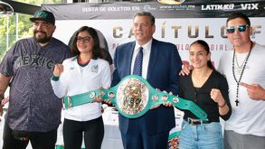 Mujeres con el puño en lo alto mientras sostienen un cinturón de boxeo.