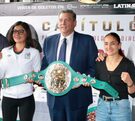 Mujeres con el puño en lo alto mientras sostienen un cinturón de boxeo.