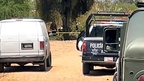 Vehículo forense, patrulla policial y auto del Ejército estacionados en un camino de terracería.