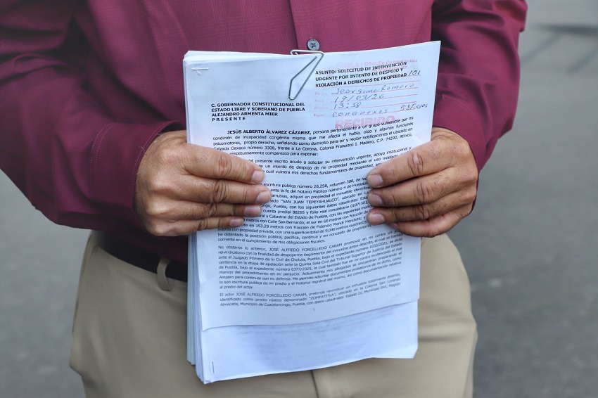 Hombre sostiene papeles de un juicio con las manos.