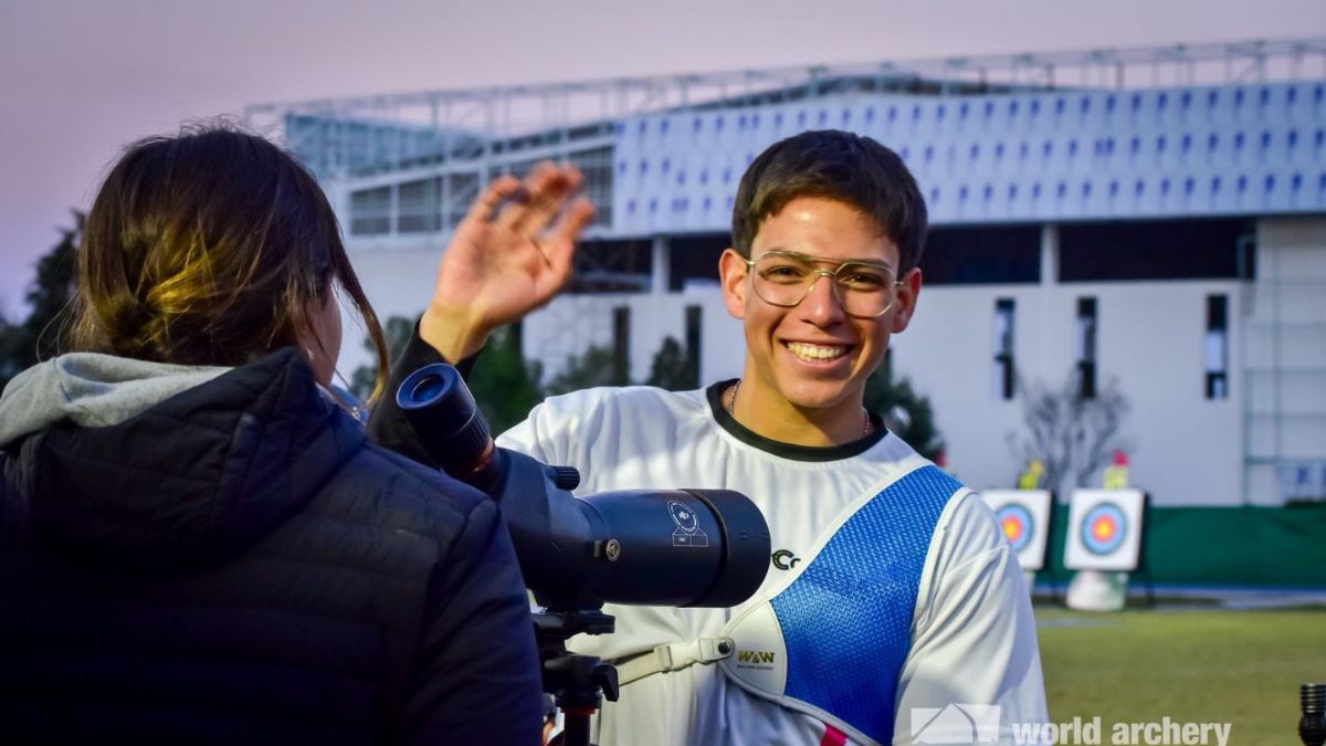 Joven arquero sonríe tras su participación en la Copa Presidente de Tiro con Arco, sosteniendo su equipo y reflejando la emoción del momento.