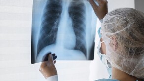 Mujer con ropa médica sosteniendo rayos x