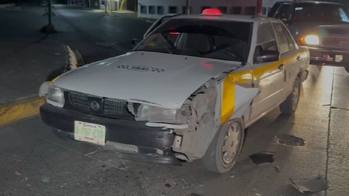Se observa un carro amarillo color amarillo, es taxi, está chocado por la parte frontal.