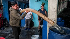 Hombre traspasando agua potable a través de una tubería.
