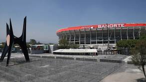 Vista panorámica de un estadio en la Ciudad de México rodeado de zona urbana, con gran afluencia de personas y vehículos en sus alrededores.