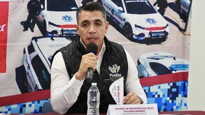 Hombre con micrófono sobre la mano habla ante un público.