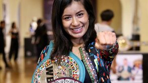 Mujer con cinturón de box sobre el hombre y con el puño hacia adelante.