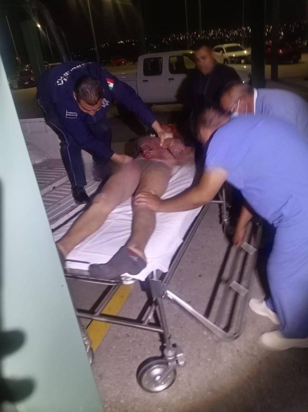 Hombre semidesnudo siendo atendido en una camilla.