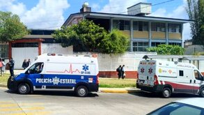 Ambulancias y patrulla de policía estacionadas afuera de una escuela en Veracruz.