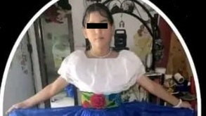 Niña con traje típico y los ojos cubiertos para preservar su identidad.
