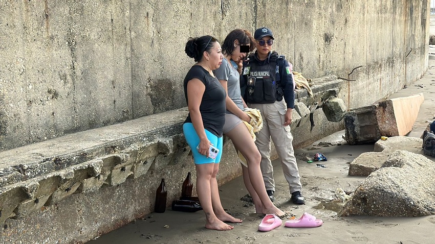 Policías resguardan a una joven tras ser rescatada del agua en Coatzacoalcos, Veracruz.