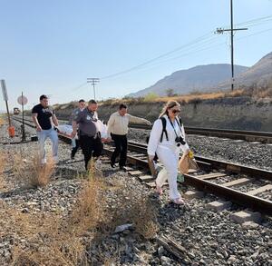Personal de servicios periciales y autoridades trasladan un cuerpo localizado a un costado de las vías del tren en una zona rural al sur de Saltillo.