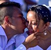 Pareja de esposos se dan un beso durante su boda.