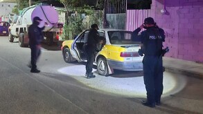 policías de acapulco revisan un taxi que fue abandonado en una calle de la zona costera