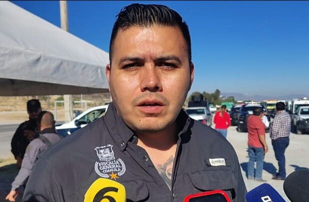 Julio César Loera, delegado de la Fiscalía General del Estado en la región sureste, habla frente a cámara en una vialidad, con personas y vehículos al fondo.