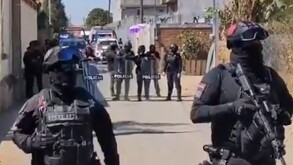 Policías armados resguardan una escena de crimen en Puebla.