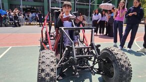 Niño montado en un vehículo motorizado hecho artesanalmente.