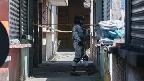Policía armado camina por el pasillo de un mercado.
