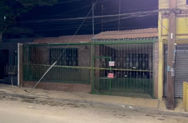 Vista de una calle con banqueta y construcciones cercanas a una pared rocosa, en una zona urbana donde se desarrolló un operativo relacionado con un cateo.