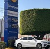 Automóvil blanco estacionado frente al letrero de una gasolinera Smartgas en Jalisco