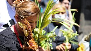 una mujer sostiene una palma durante el domingo de ramos