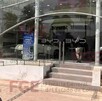 Vista del exterior de una agencia automotriz BYD en Colima con un militar sosteniendo una arma larga al lado de las escaleras