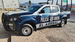 Patrulla de la Policía Municipal de El Arenal estacionada sobre un camino de tierra al lado de un tramo carretero